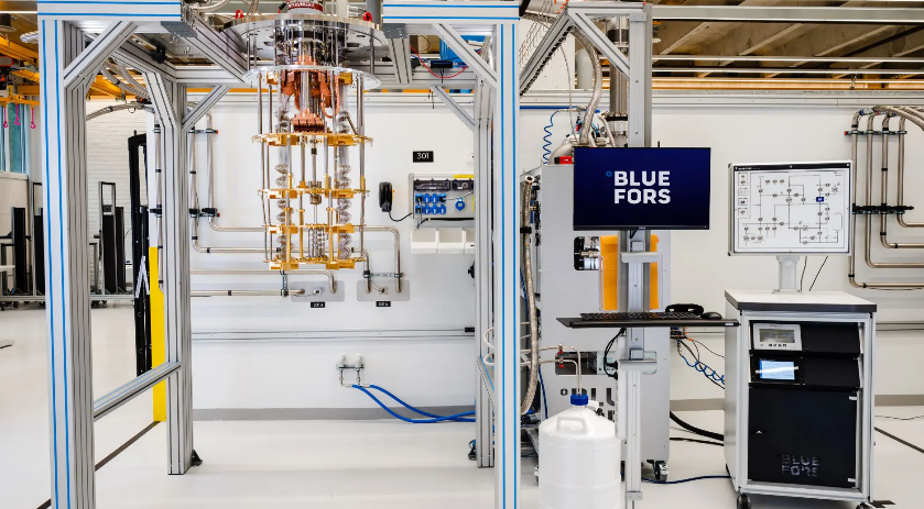 Bluefors cryogen-free dilution refrigerator system showing the vertical cooling stack with multiple temperature stages and the gas handling system with control electronics on the right.